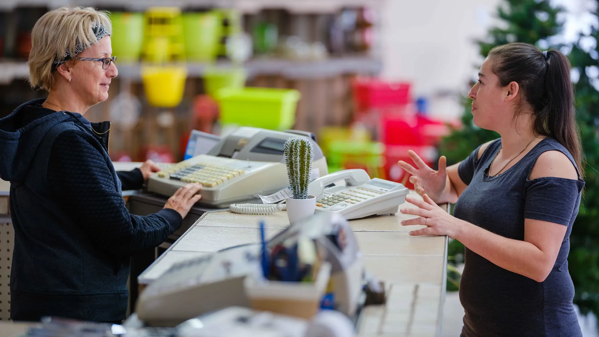 Une caissière et sa cliente en discussion au comptoir
