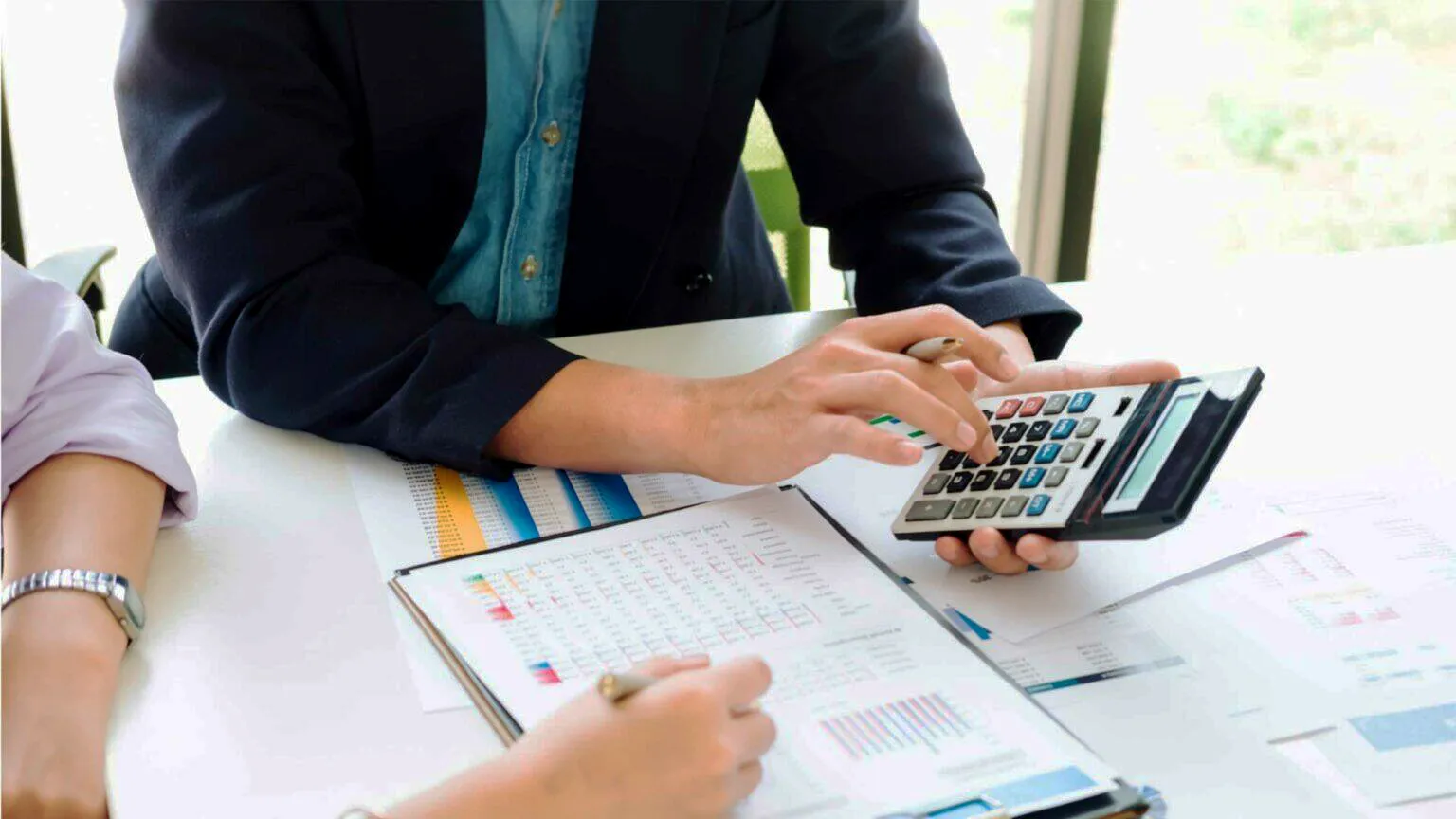 Un personne qui utilise sa calculatrice pour son rapport