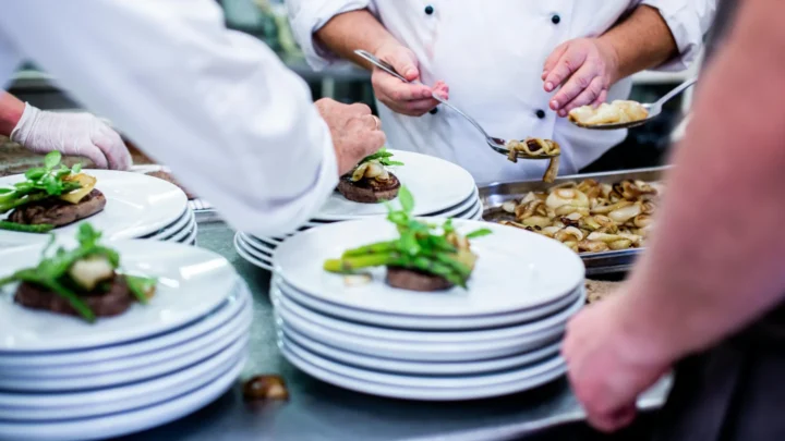 Une équipe de chef en cuisine qui manipule des assiettes et aliments