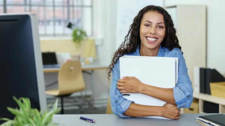 Une adjointe administrative qui sourit derrière son bureau