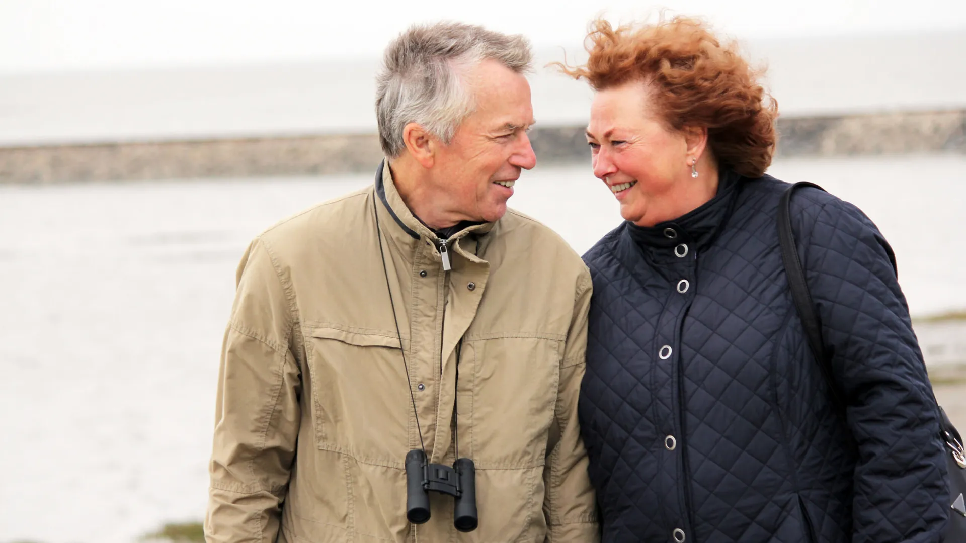 Un couple de retraité qui prend une marche sur le bord de l'eau