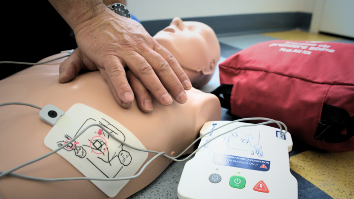 Personne pratiquant sur un mannequin à donner massage cardiaque